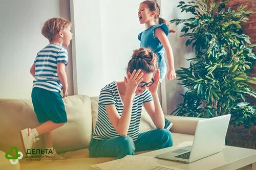 Женщина держится за голову, на фоне кричат дети